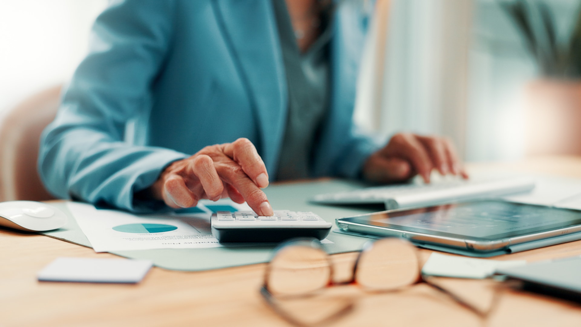 A woman working on a trade portal while reviewing prices